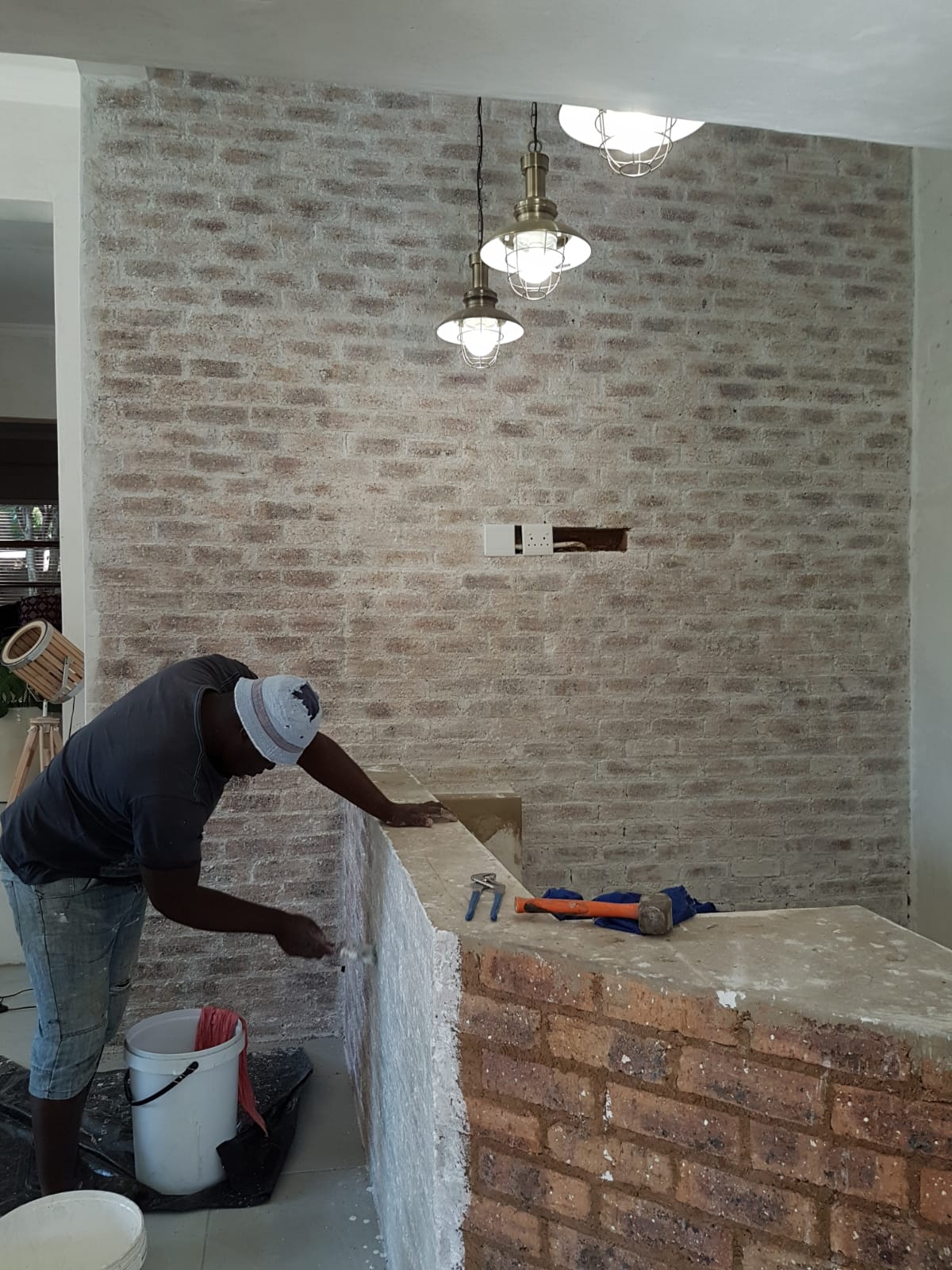 Decorative finishing work on an interior brick wall and counter