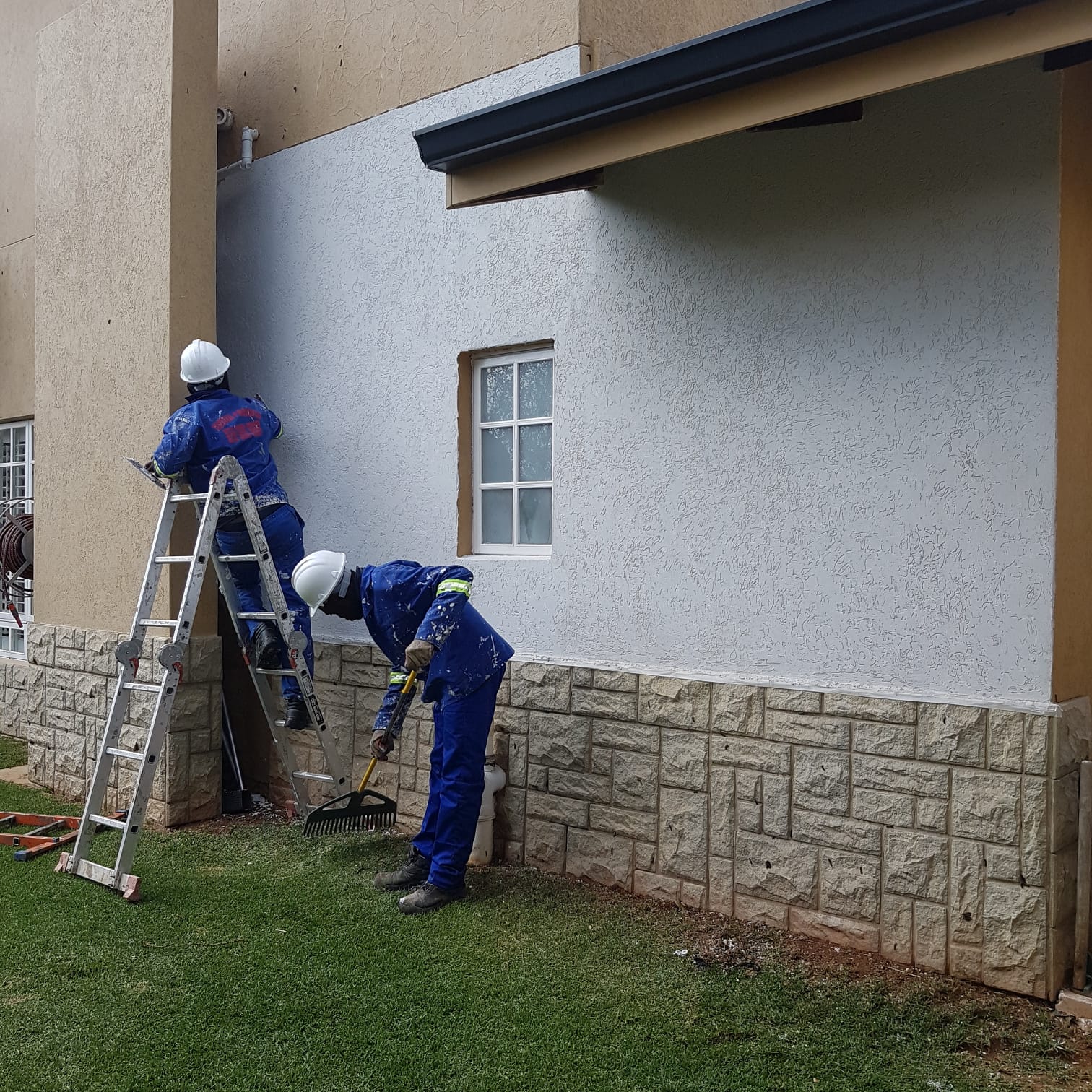 Exterior painting in progress on a textured wall