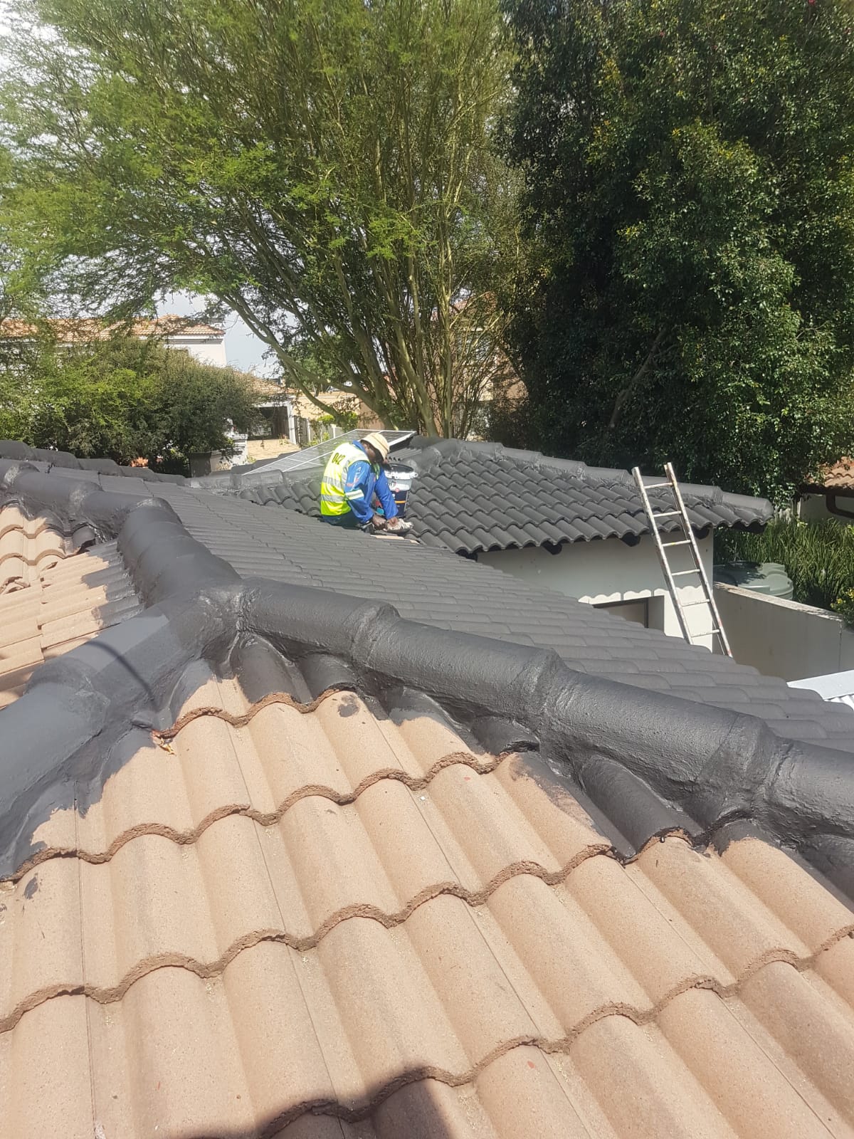 Roof waterproofing work along the ridge and joints of a tiled roof